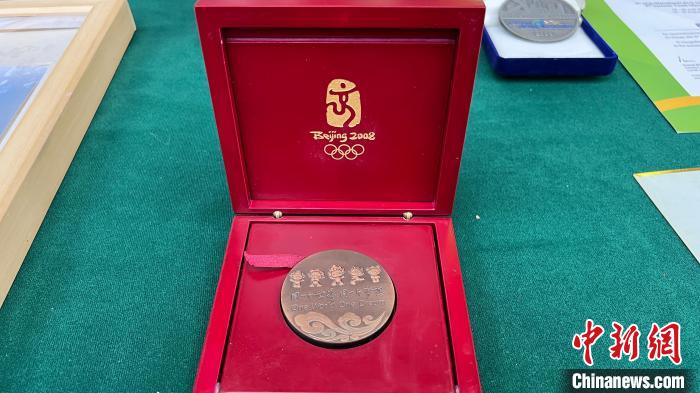 图为前中国女足队长徐媛向重庆体育博物馆捐赠了2008年参加北京奥运会获得的纪念奖牌。　肖江川 摄